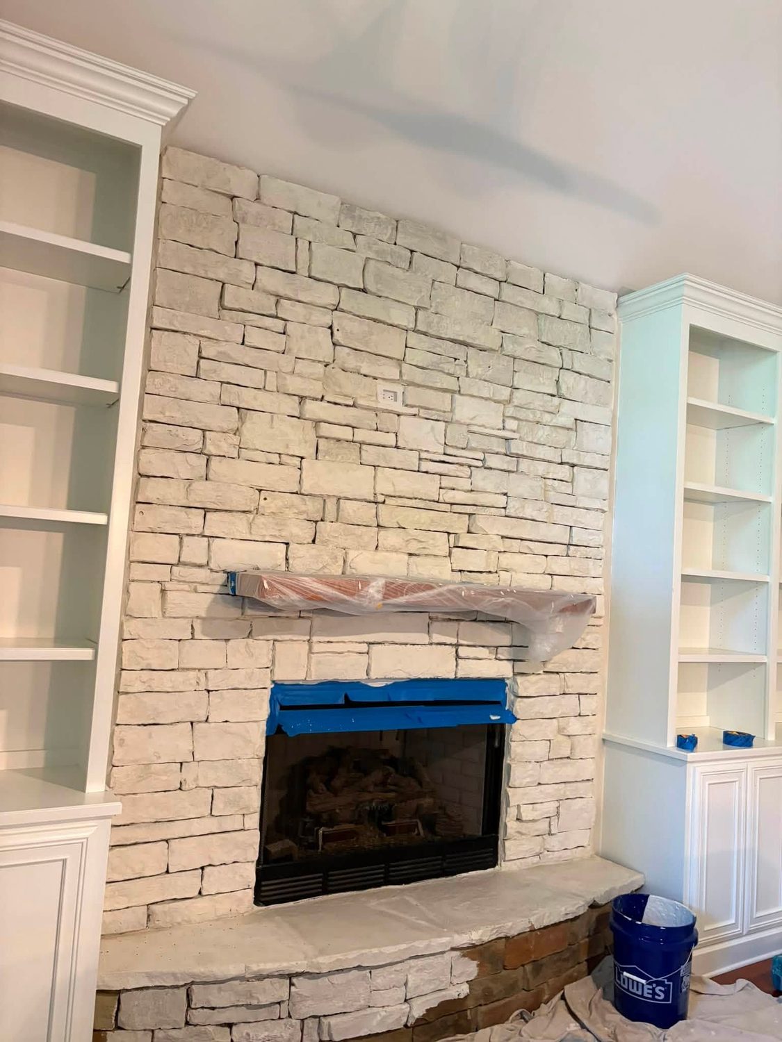 A stone fireplace painted out white by Carolina Superior Painting LLC