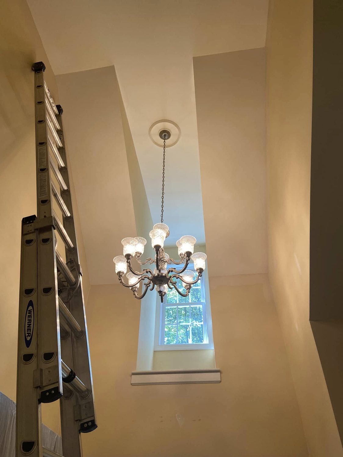 A two storey foyer, ladders up by Carolina Superior Painting LLC