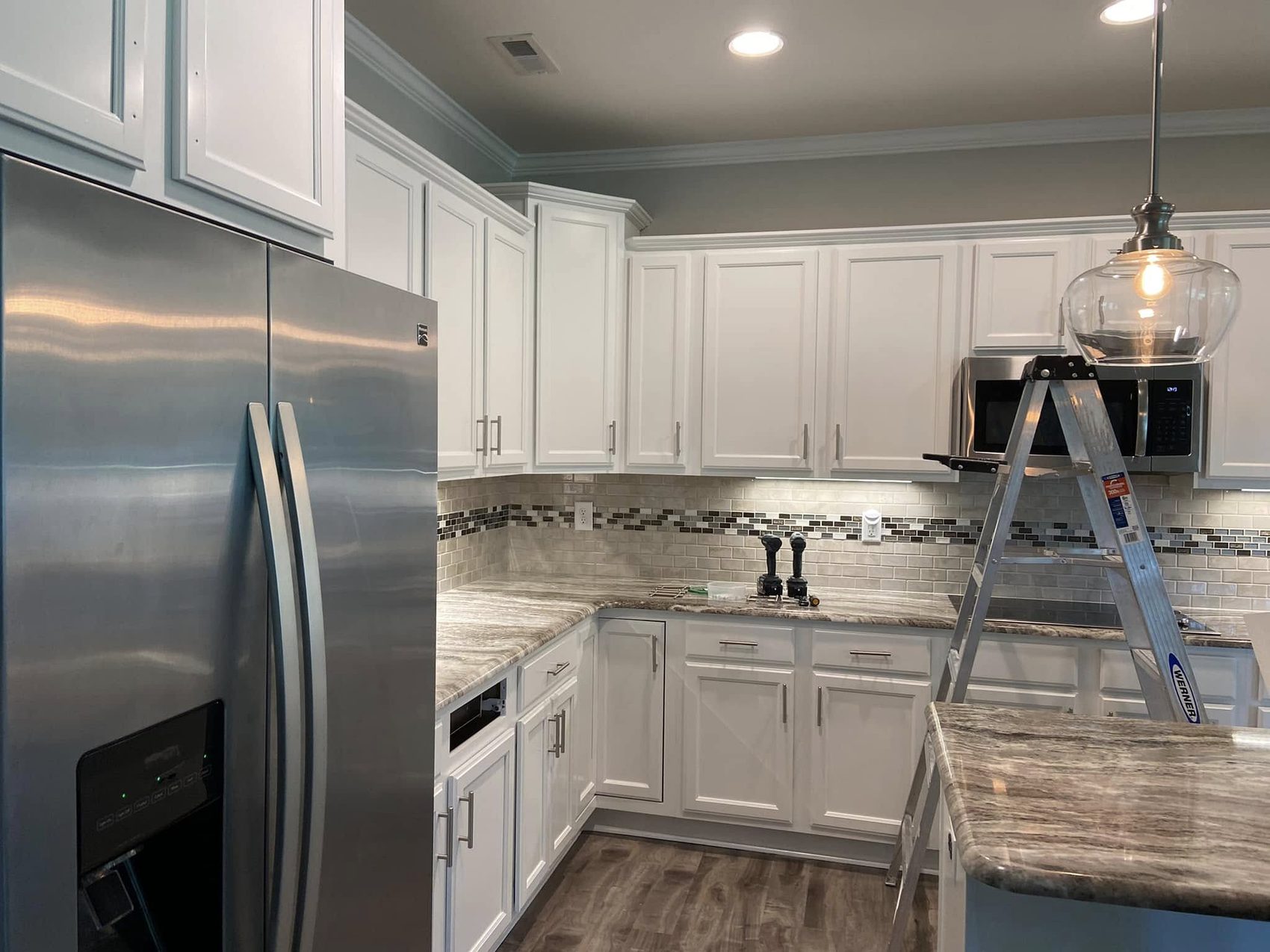 Wall and base cabinets finished white by Carolina Superior Painting LLC