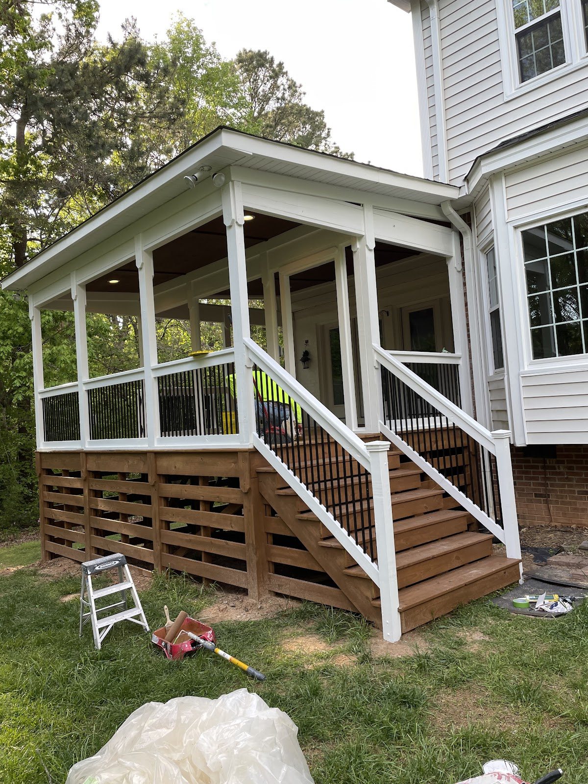 A screened porch and deck rail in white by Carolina Superior Painting LLC